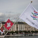 world trade organization: Image of WTO flag flying next to a Swiss flag